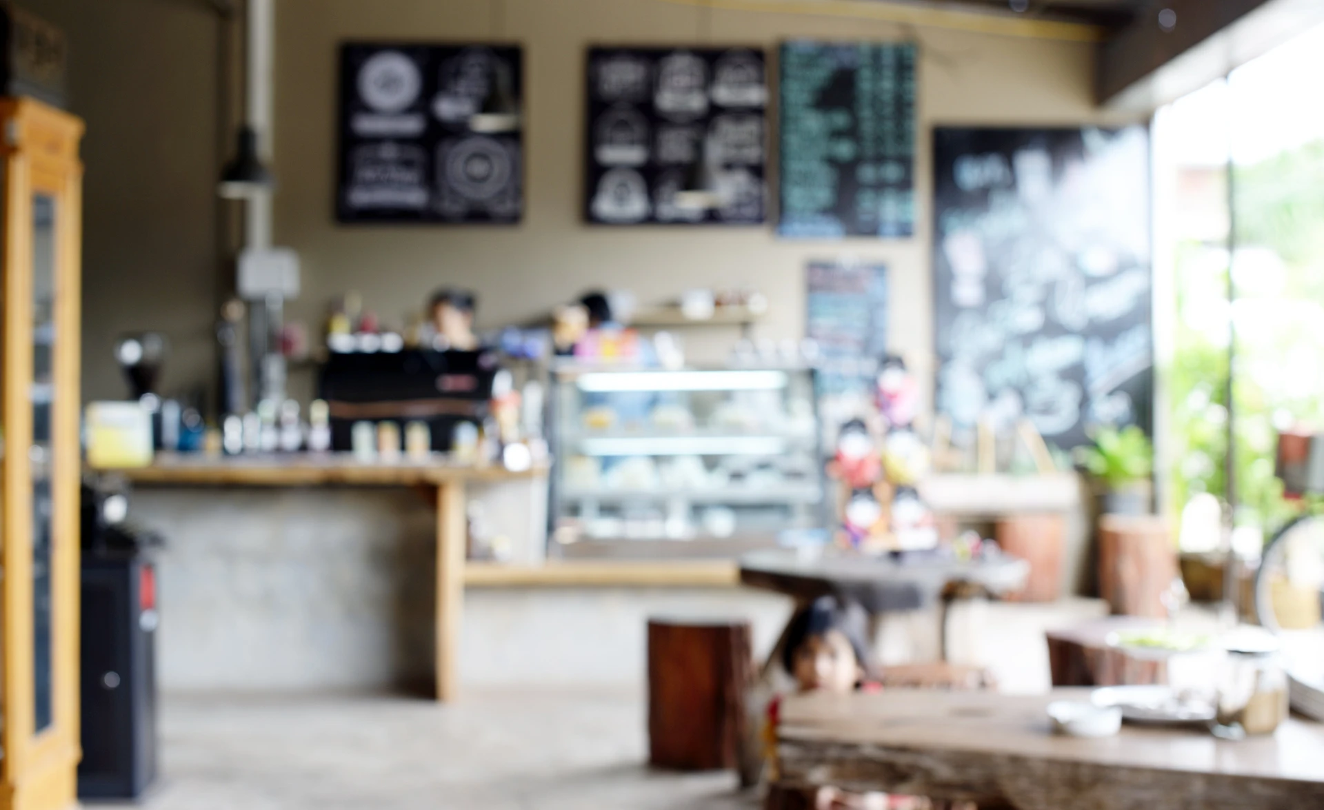 Intérieur de café moderne avec comptoir en bois, vitrine réfrigérée, machine à espresso professionnelle et personnel en service